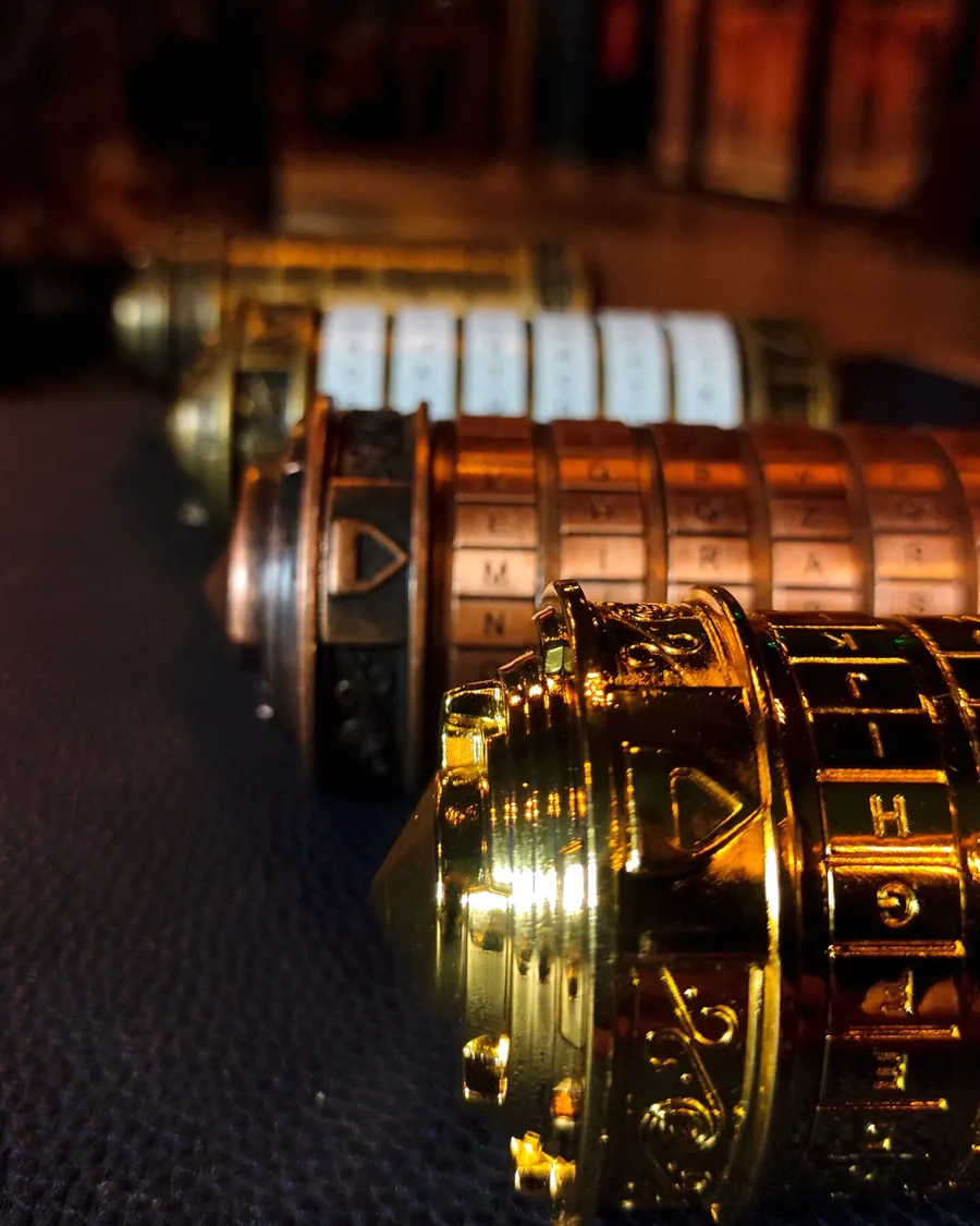 Cryptex de latón con anillos de letras sobre una mesa de la sala