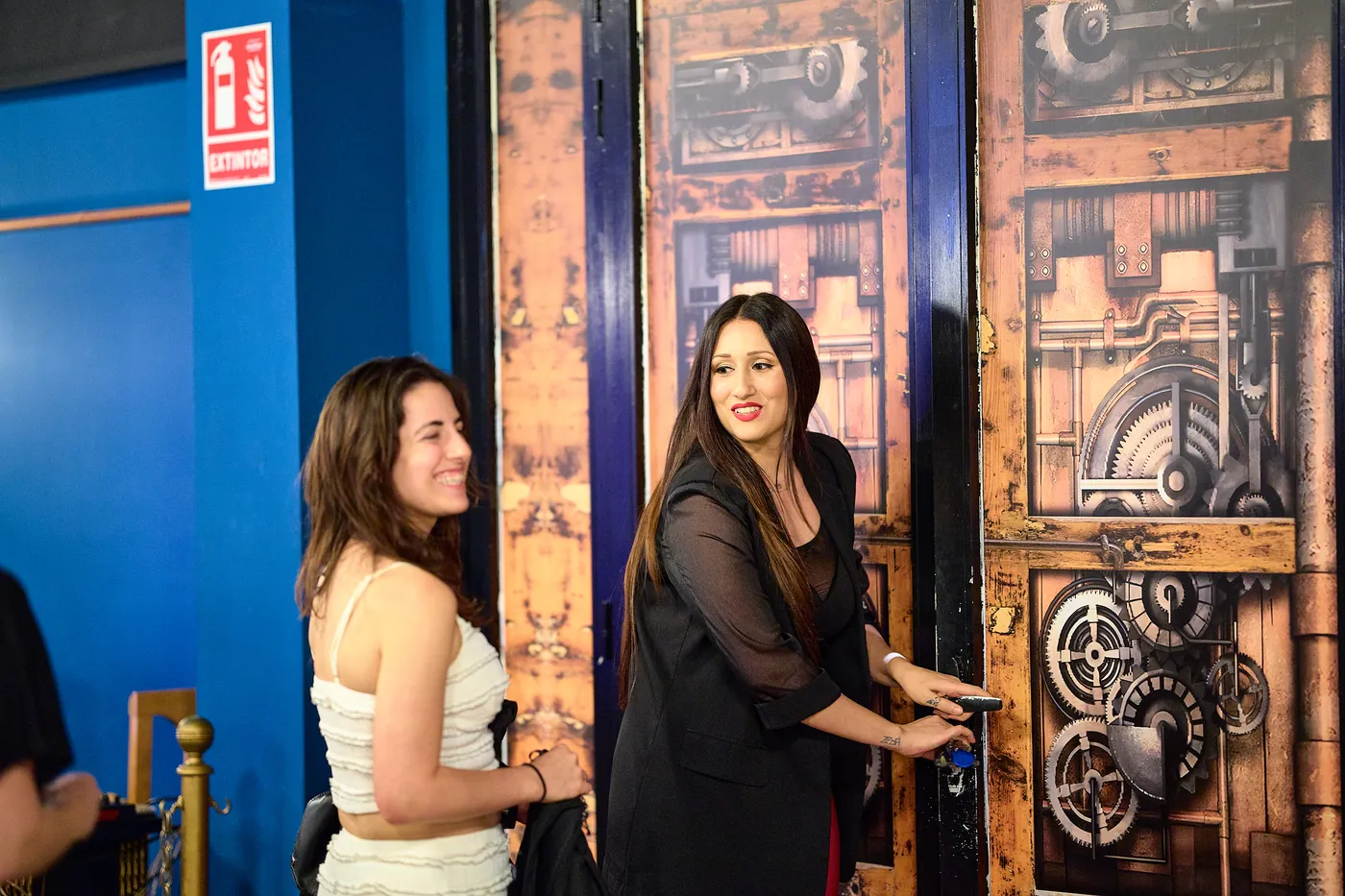 Rocío abre la puerta de engranajes de la sala a las espectadoras