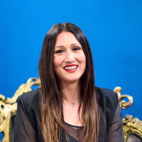 Rocío Fernández sonríe sentada en un sillón dorado de la sala